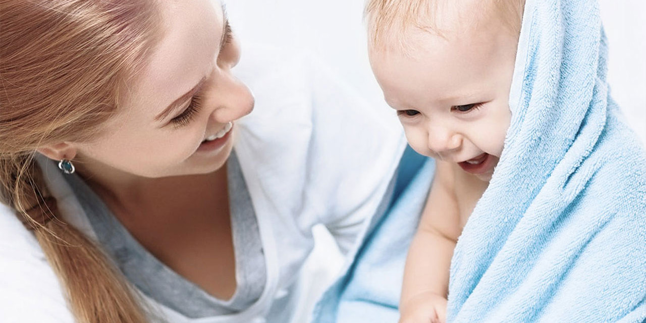 Mother with baby wrapped in towel