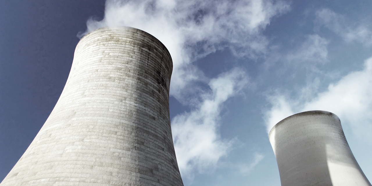 Kraftværk skorstene med blå himmel og røg