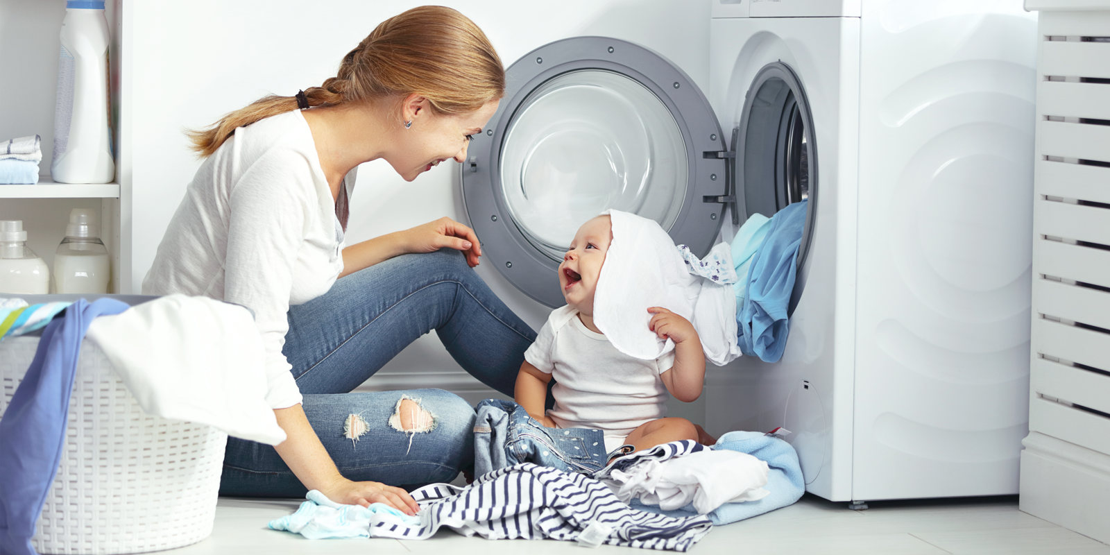 Mor og baby ved vaskemaskine Mor og baby ved vaskemaskine