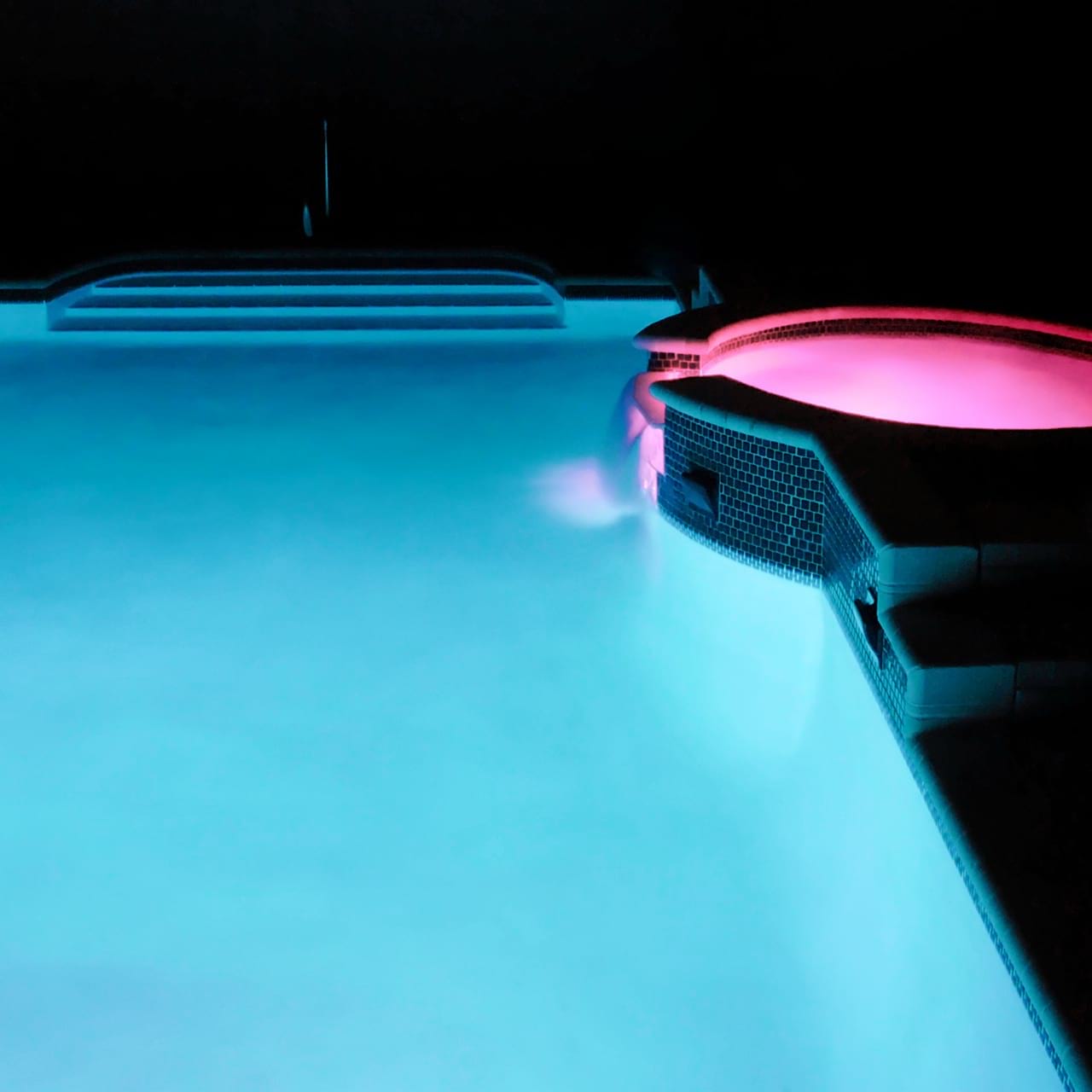 Stimmungsvolle Poolbeleuchtung in blau und lila.