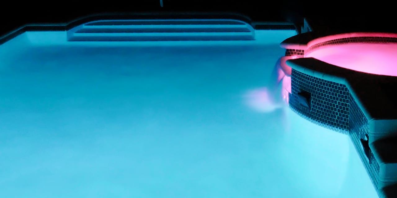 Stimmungsvolle Poolbeleuchtung in blau und lila.