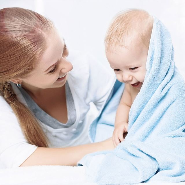 Mother with baby wrapped in cozy blanket