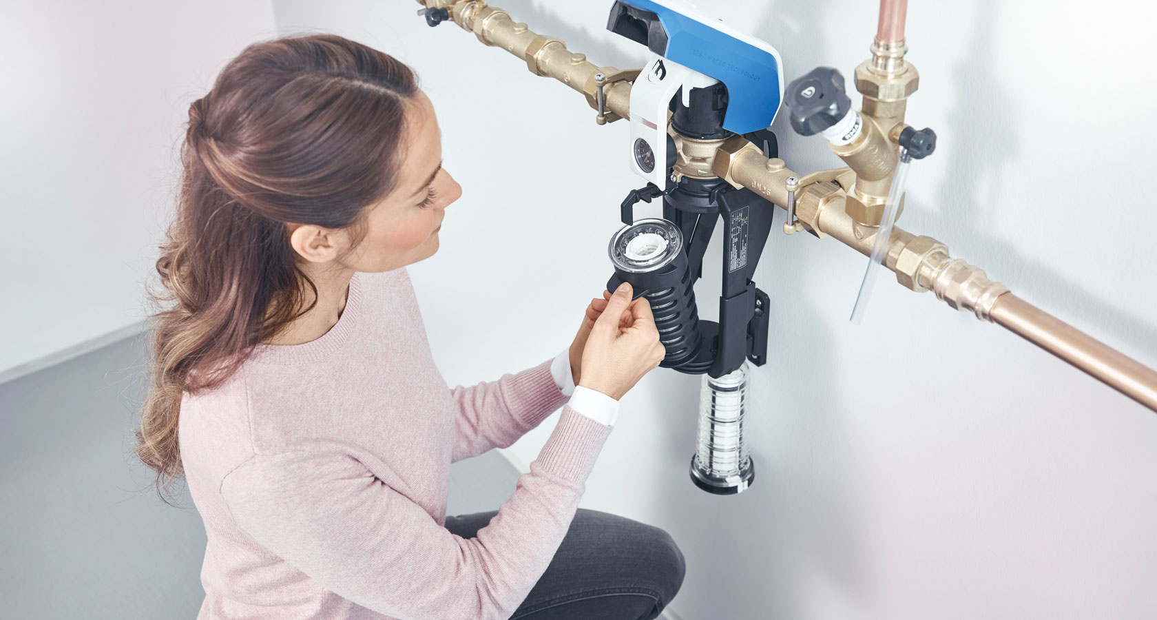 Frau wechselt Filter an Wasserfilter. 