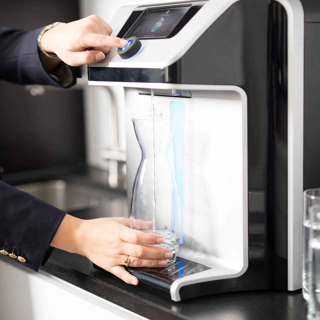 Frau bezieht Wasser am Wasserspender BWT Palaimon P7.