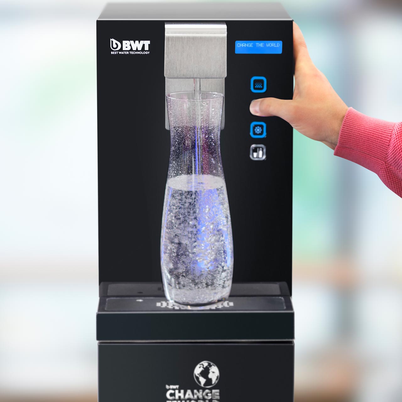 Person drückt Knopf und Wasser sprudelt aus Wasserspender.