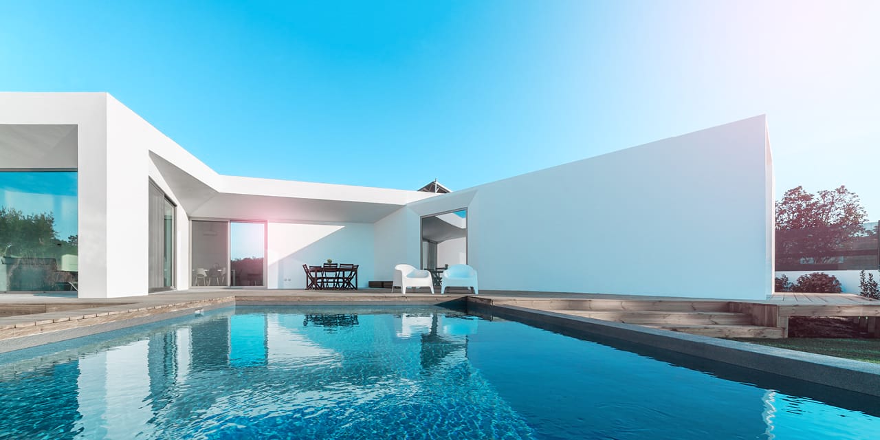 Pooltrend für 2020: Pool mit dunklem Innenraum, im Hintergrund ein weißes Haus.