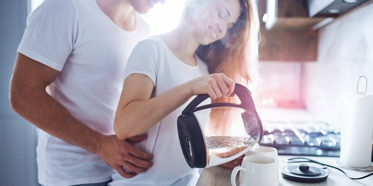 Junges Paar genießt Kaffee am Morgen mit gefiltertem und mineralisiertem Wasser.