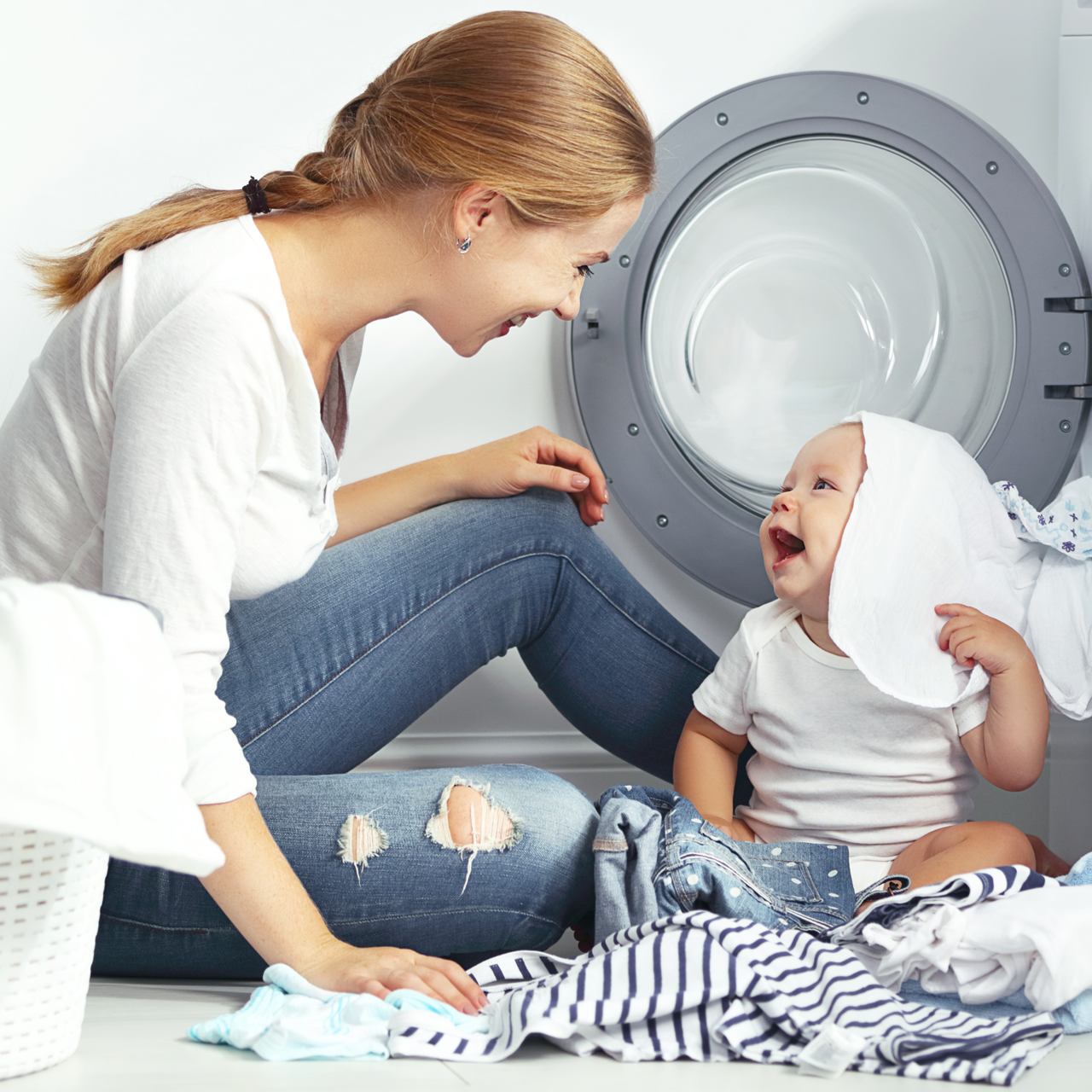 Mor og baby ved vaskemaskine