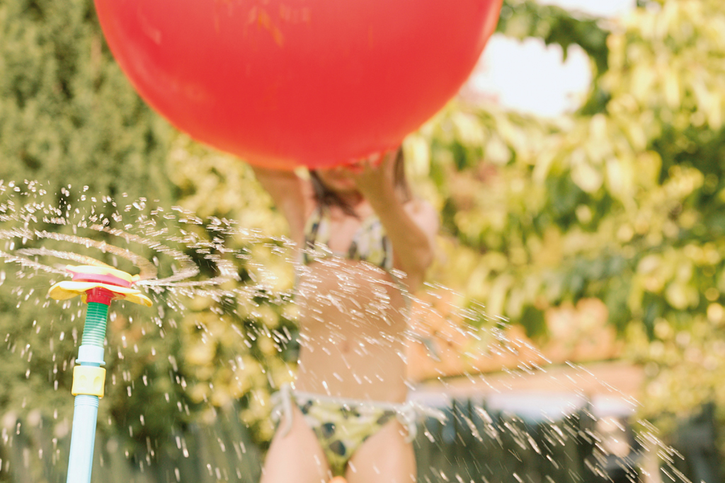 child playing with ballon in the garden