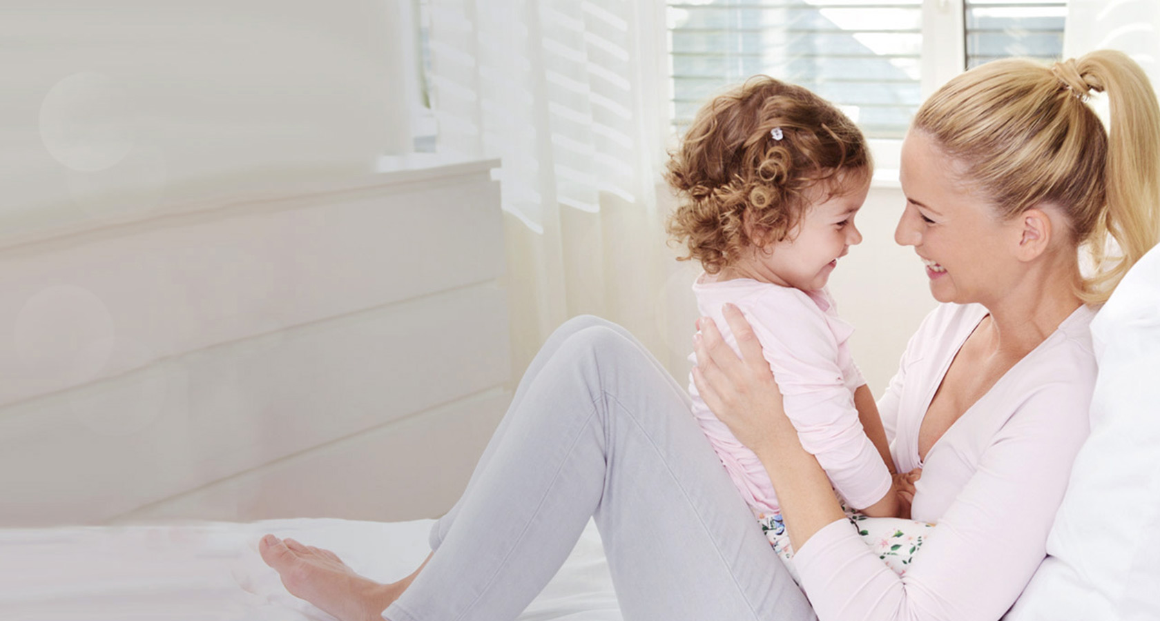 Mutter und Tochter kuscheln im Bett