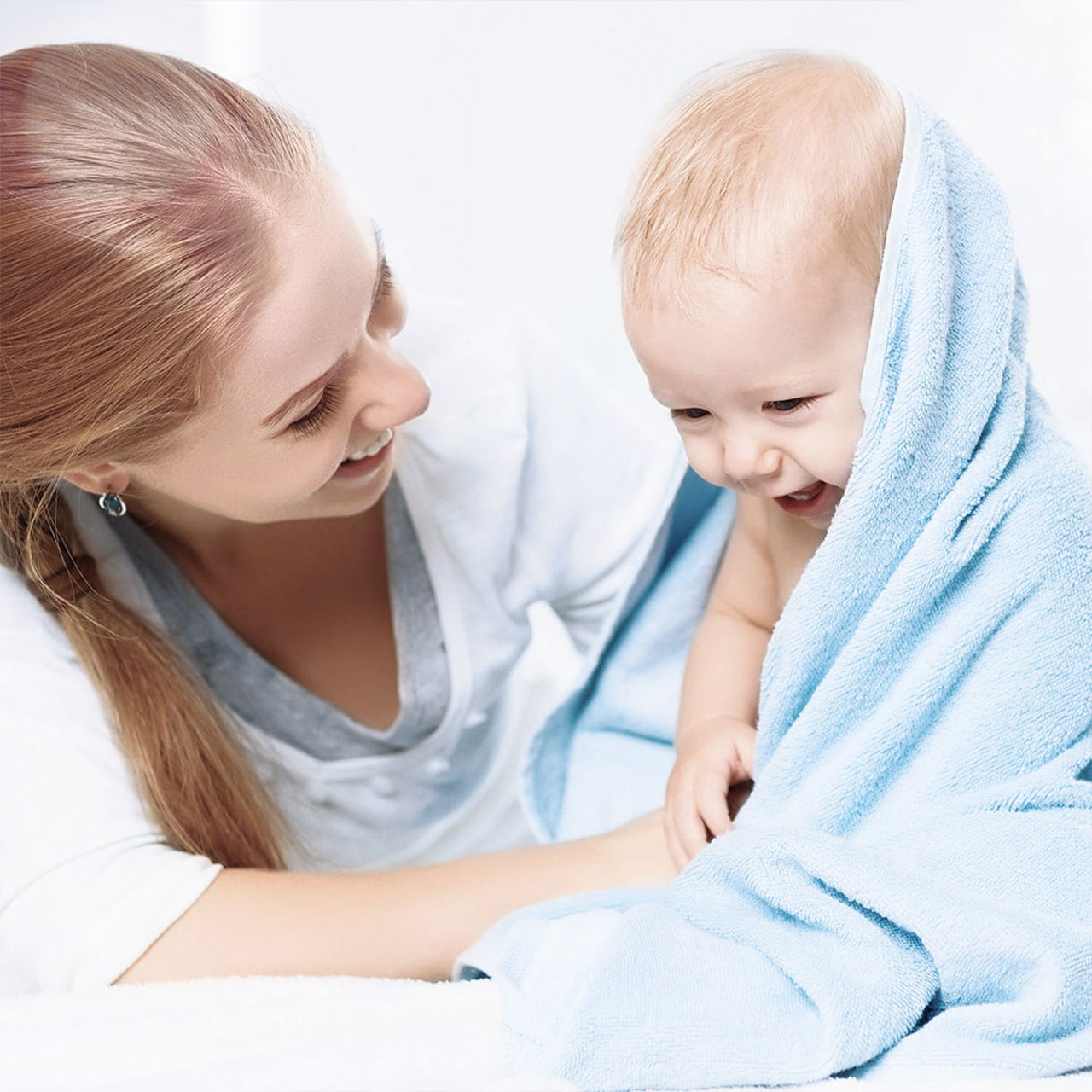 Mother with baby wrapped in cozy blanket
