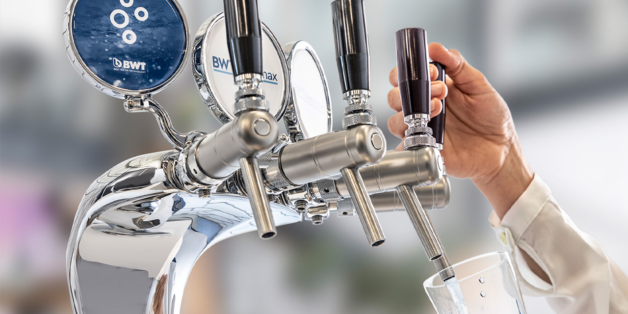 La main puise de l'eau au BWT WasserBar.