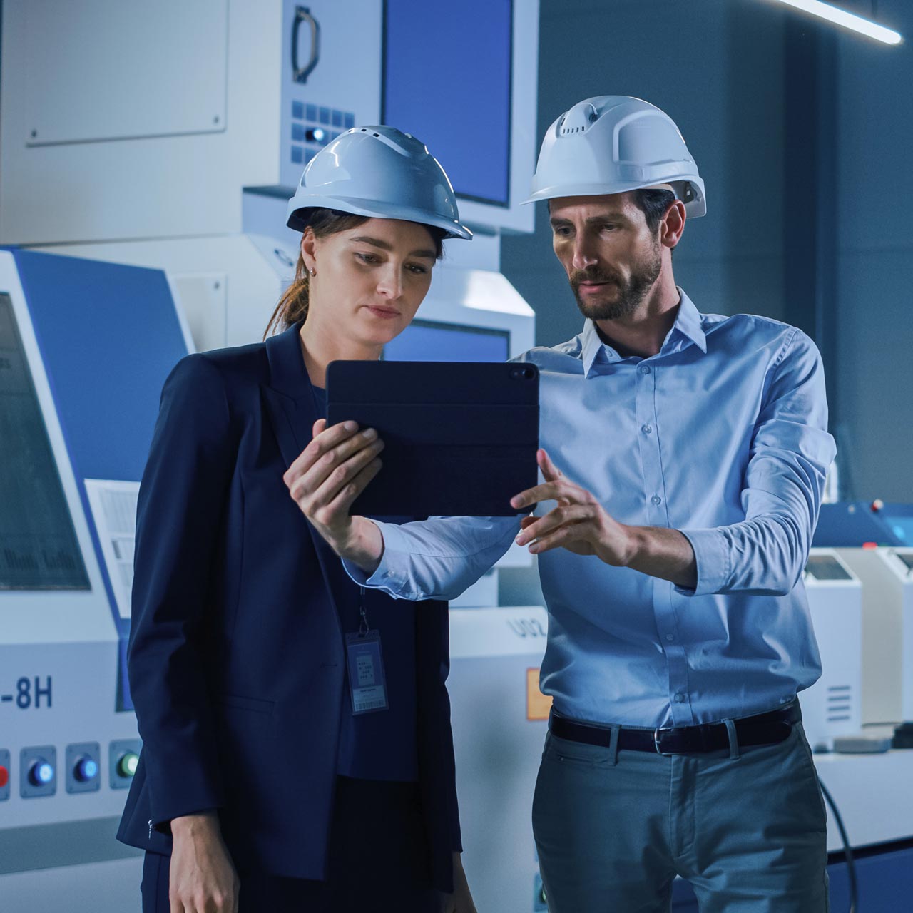 Une femme et un homme regardent une tablette. 