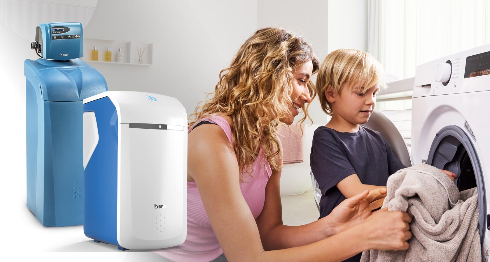 Une femme et son fils sortent le linge de la machine à laver. Deux adoucisseurs d'eau de BWT sont placés sur la photo.