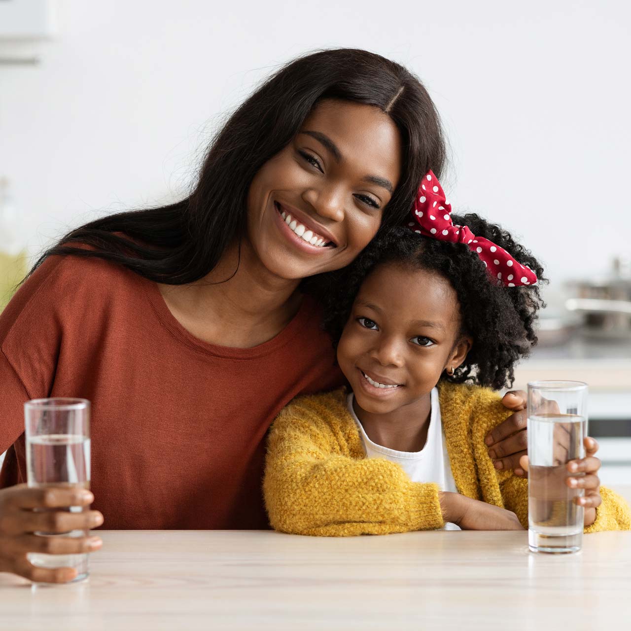 La mère et la fille boivent un verre d'eau.