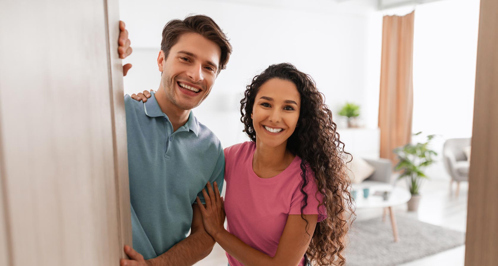 Un homme et une femme se tiennent devant la porte d'entrée.