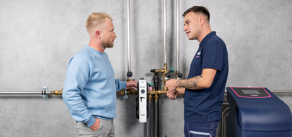 Le technicien de service parle avec le client au sujet du filtre à levier unique BWT.