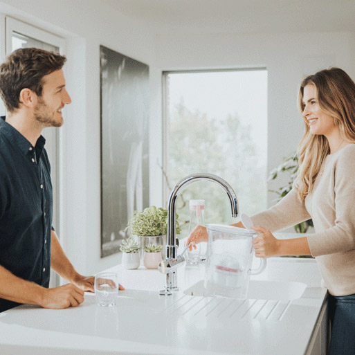 Une femme laisse couler de l'eau du robinet. 
