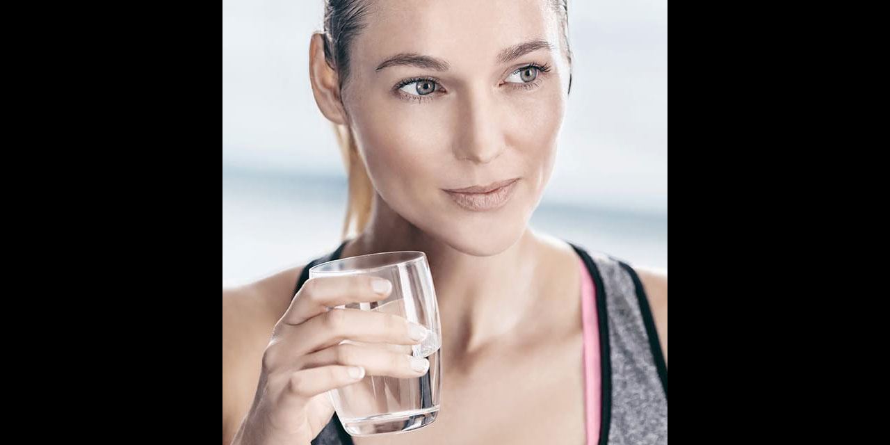 femme boit de l'eau au sport