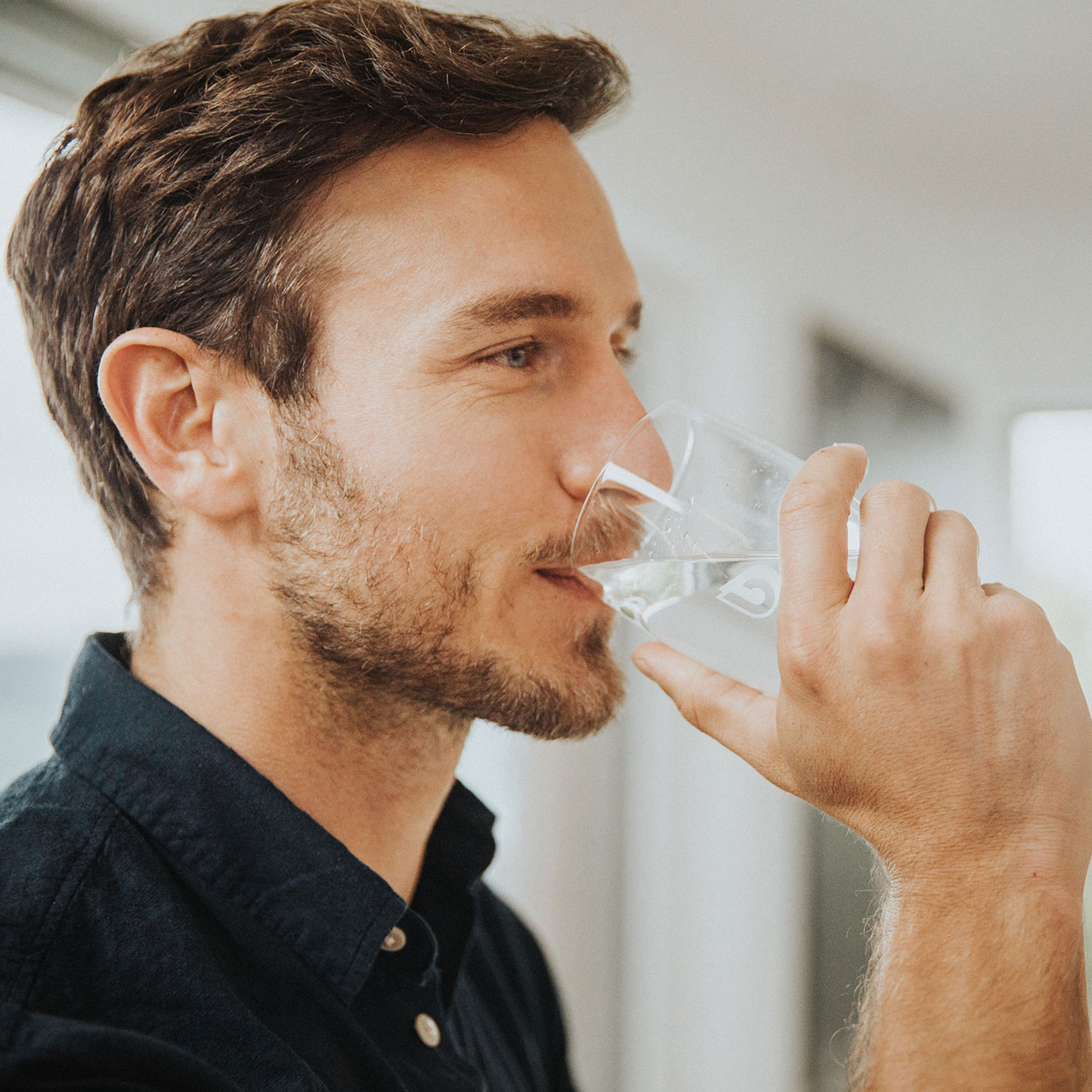 Homme boit un verre d'eau