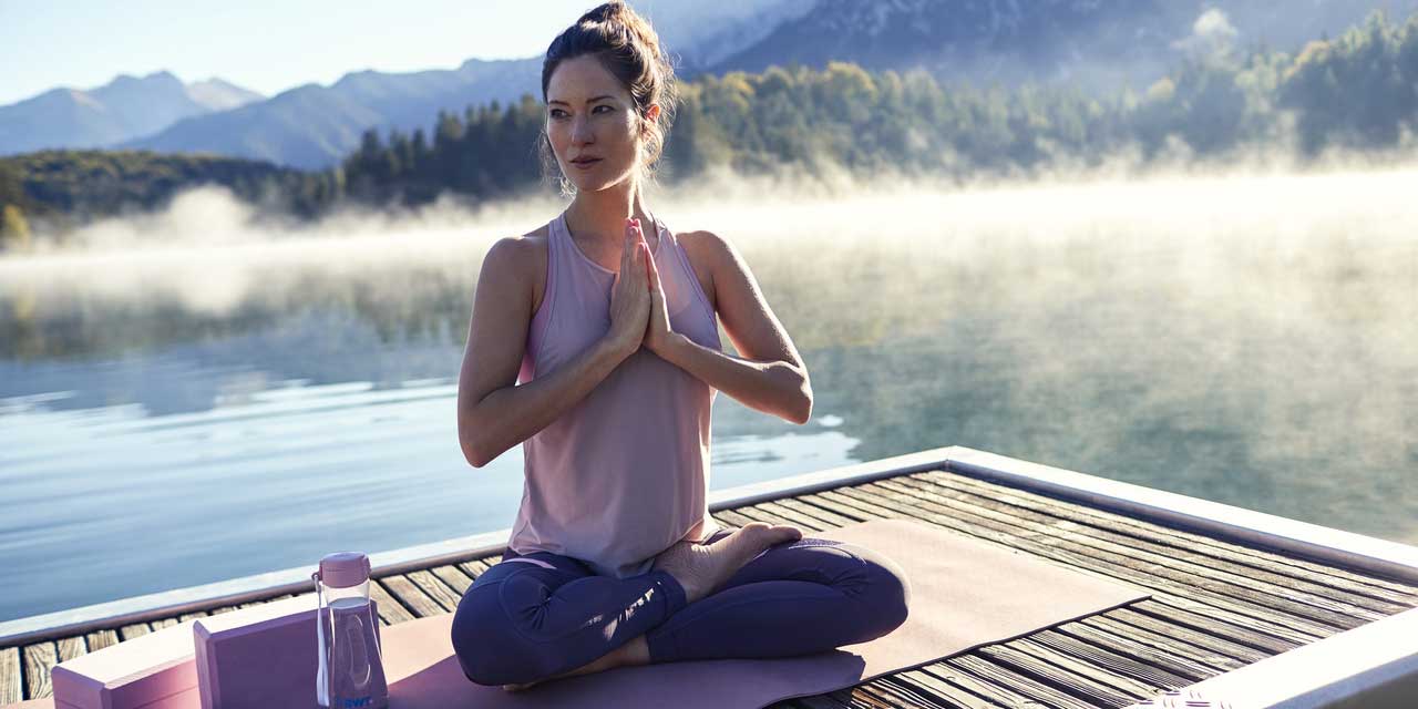 femme fait du yoga au bord de l'eau