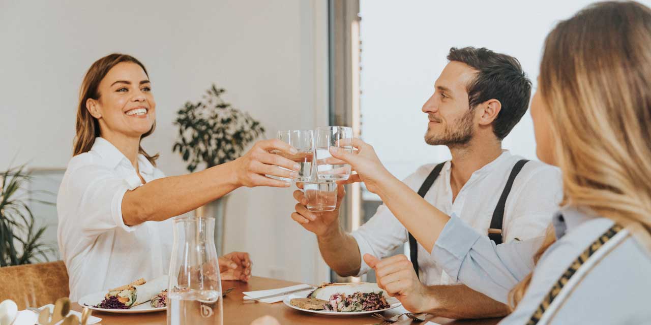 des amis trinquent à table