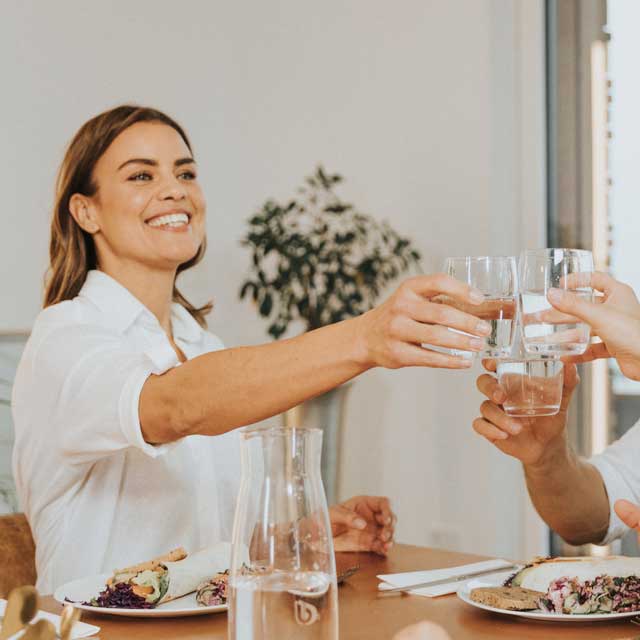 Des amis trinquent ensemble à table