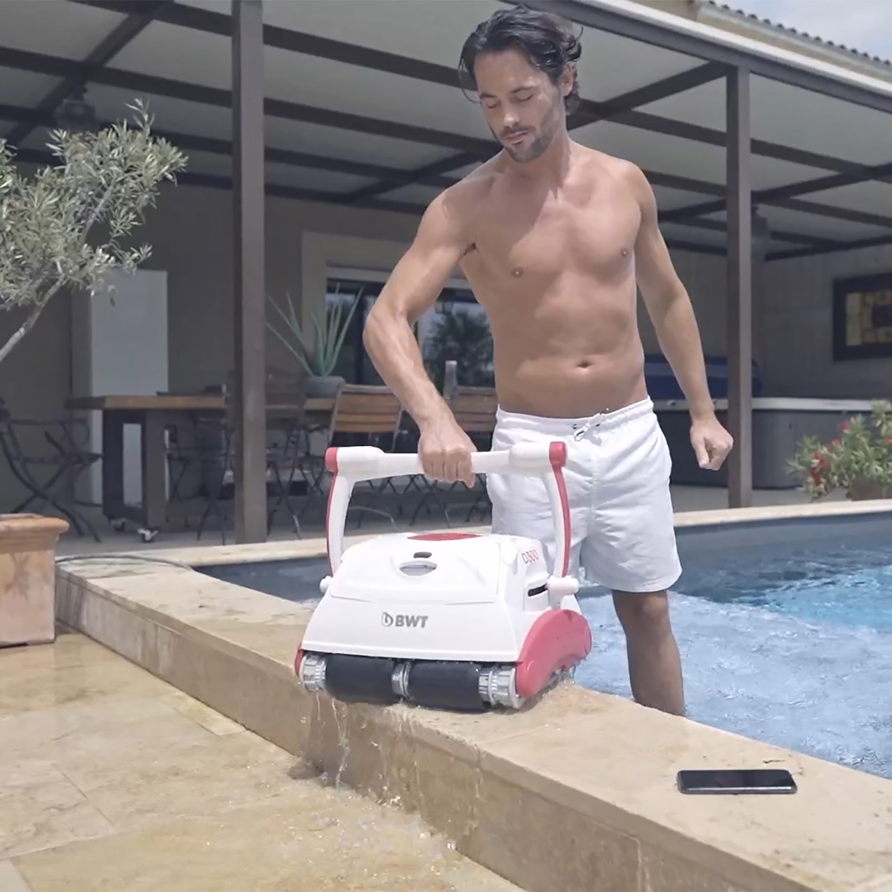 Homme portant son robot de piscine